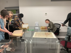 workshop participants looking at archives at Postal Museum
